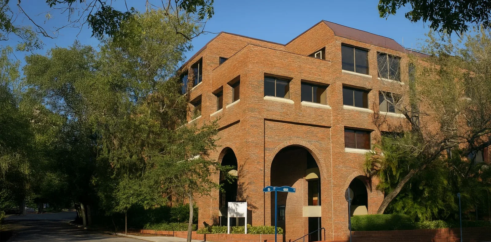 Exterior of the Coconut Grove office building with arched entry, trees, and clinic suites.