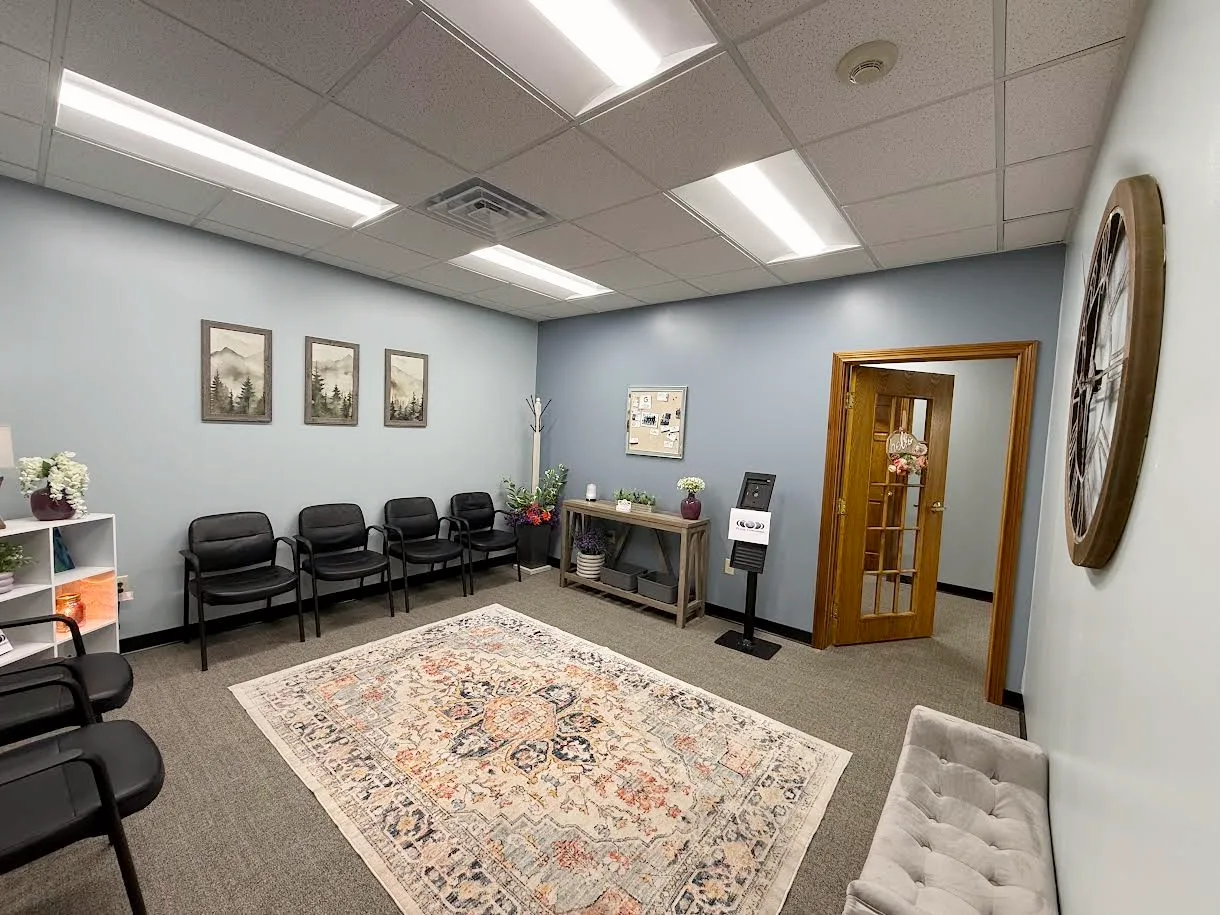 Empty Phase Forward clinic waiting area with rows of seats and reception context.