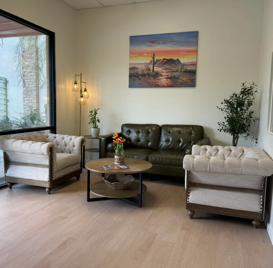 Empty Brighter Days Mesa office sitting area with sofas, chairs, plants, and artwork.
